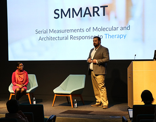 Researchers Rochelle Williams-Belizaire (seated) and Brett Johnson, Ph.D.  (standing) presenting about SMMART