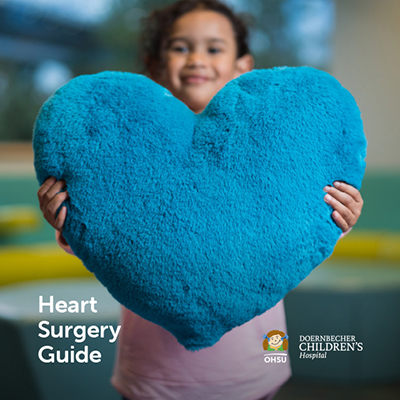 A photo of the front cover of Doernbecher Children's Hospital's Heart Surgery Guide, showing a young girl holding up a blue pillow shaped like a heart.