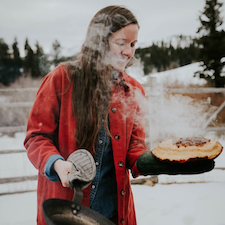 Anna Borgman standing outside with steaming bread.