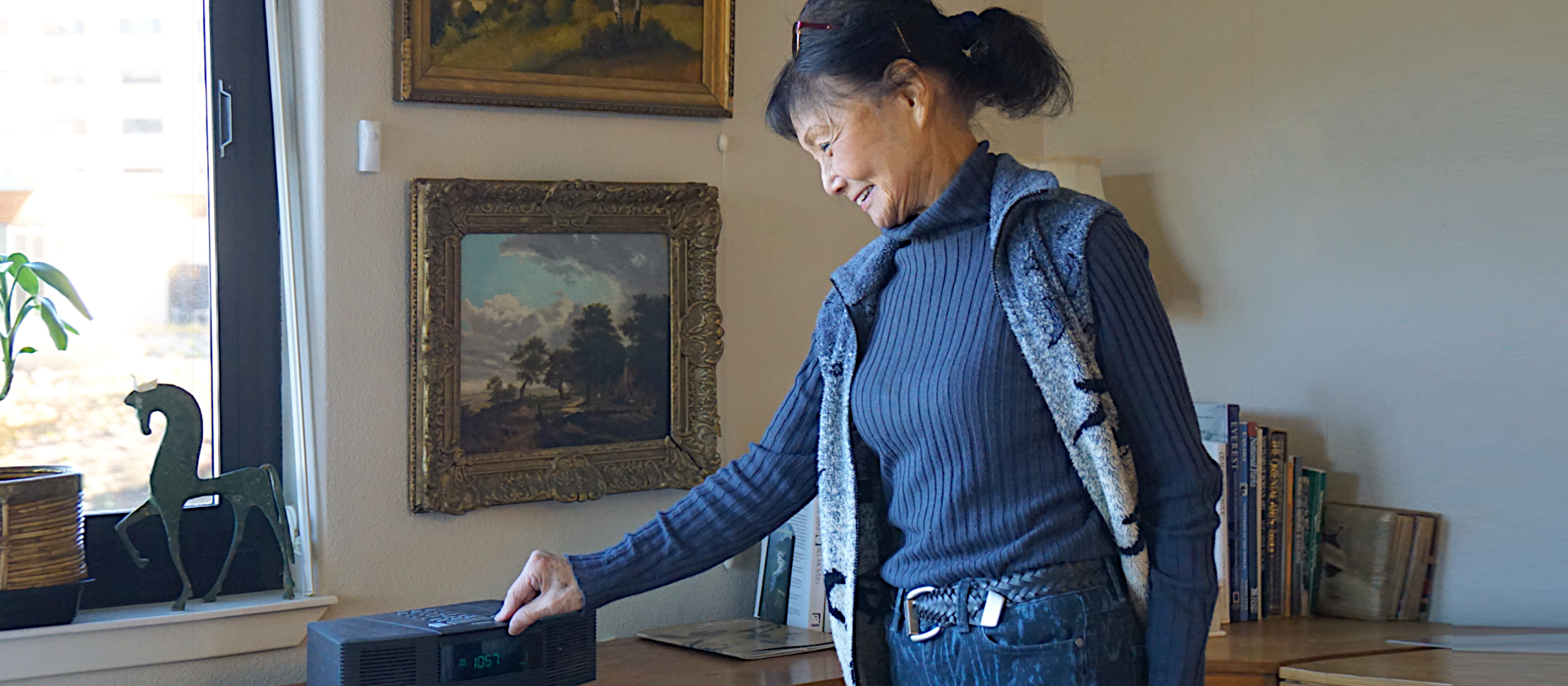 Research participant uses a radio in the living room of her apartment