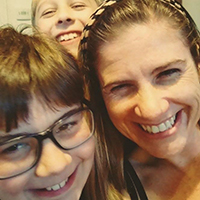 Jodi Leonard posing with her two children smiling.