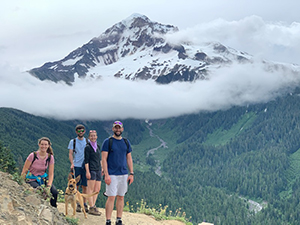 Two men, two women and one dog on a hike with Mt. Hood in the background.