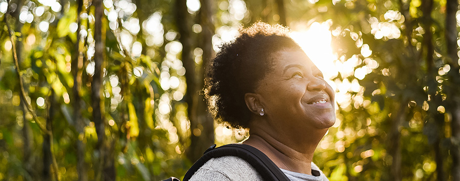 Photo of a smiling person outside in front of trees