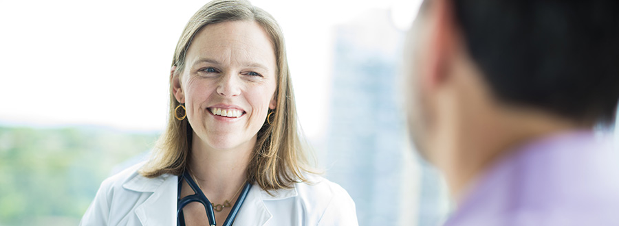 An OHSU provider smiles while speaking to a patient