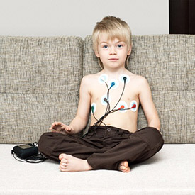 Stock photo of a child wearing a Holter monitor for his heart