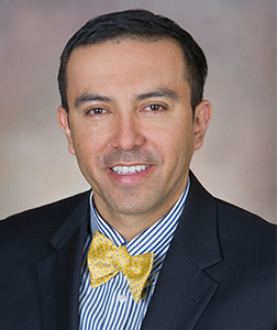 A portrait of Dr. Alex Ortega Loayza, M.D., M.C.R.