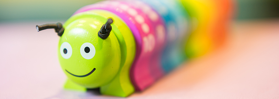 A multicolored toy caterpillar with a smile on its face.