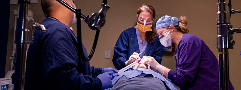 A team of dermatologic surgeons operate on a skin cancer