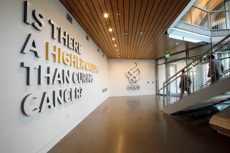 Interior of the Knight Cancer Research Building, with a wall that says "Is there a higher calling than curing cancer?"