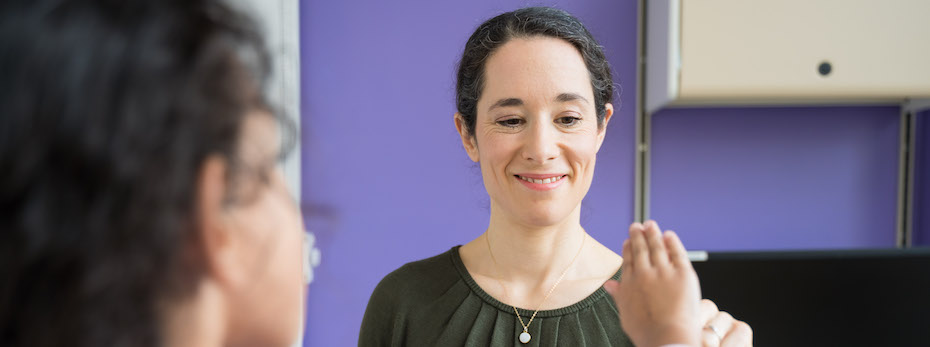 Healthcare provider with a pediatric patient in front of a wall painted purple