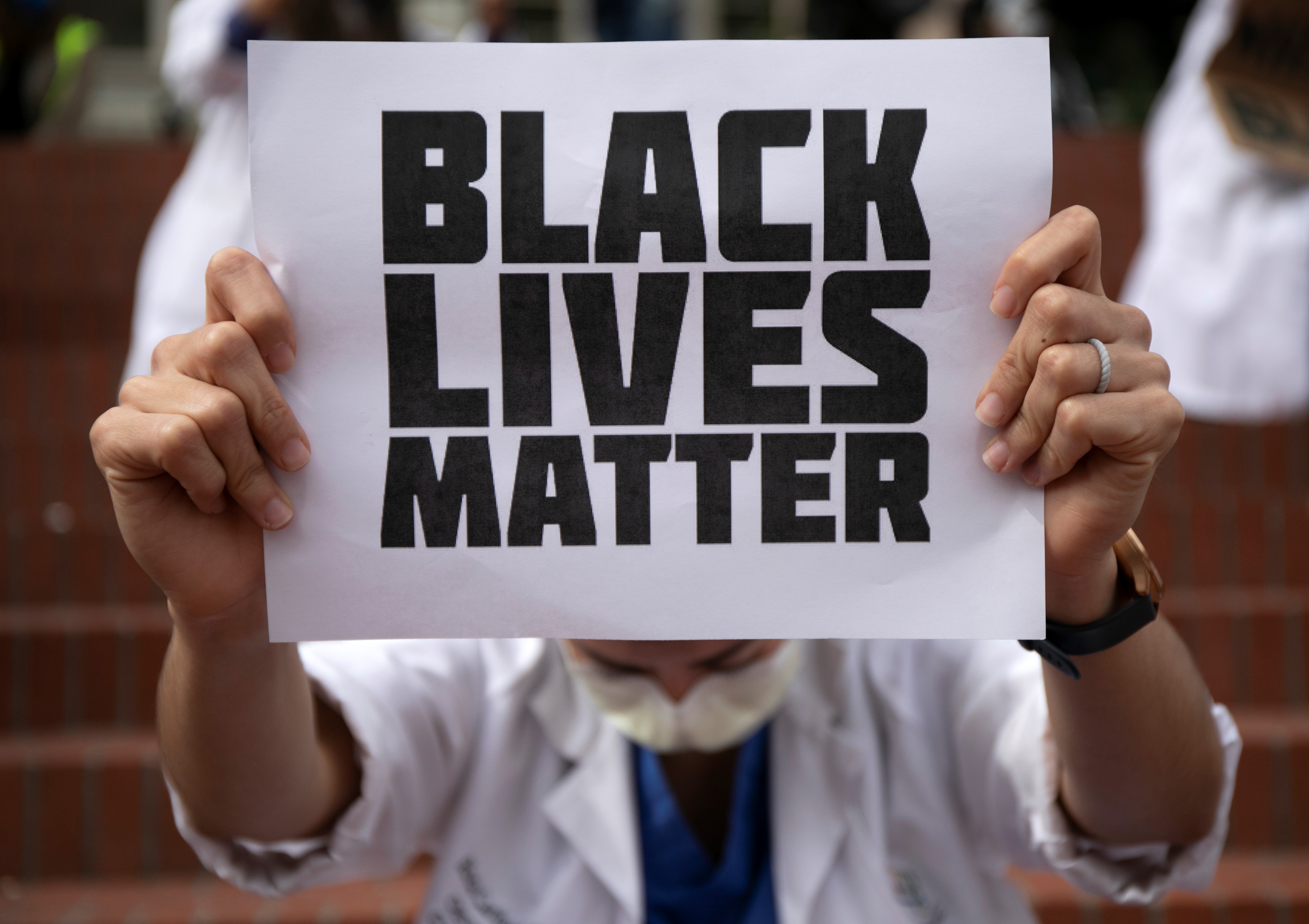 practitioner holding up sign that says, "Black Lives Matter."