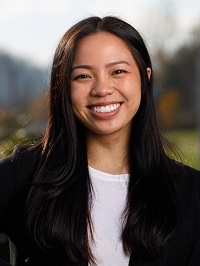 Nina Luong smiling, wearing a black sweater and white shirt