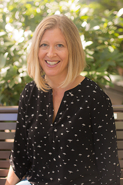 A photo of Dr. Amy Stenson sitting on a bench outside.