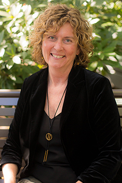 A photo of Dr. Meg O'Reilly sitting on a bench outside.
