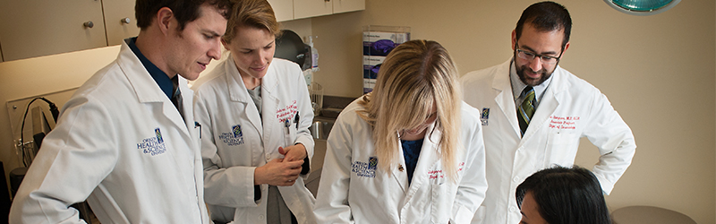 A team of providers meet with a patient