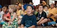 A group of children listen to an eczema talk at an event