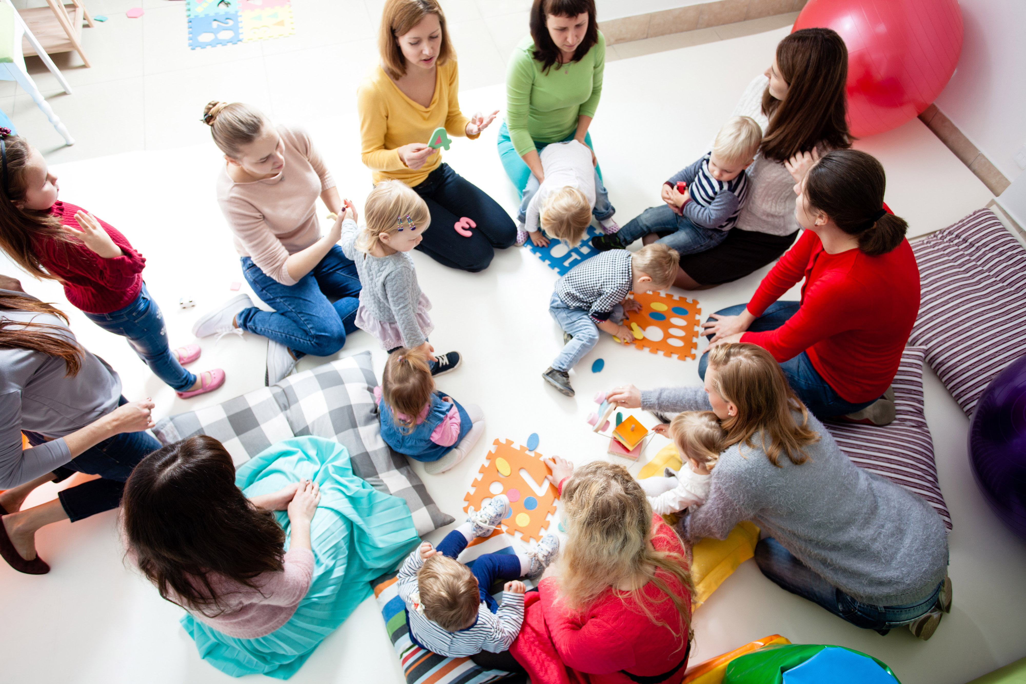 playgroup of moms and toddlers inside with toys