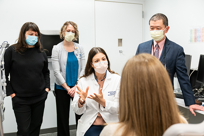 Dr. Loyo Li and her colleagues talk to a patient.