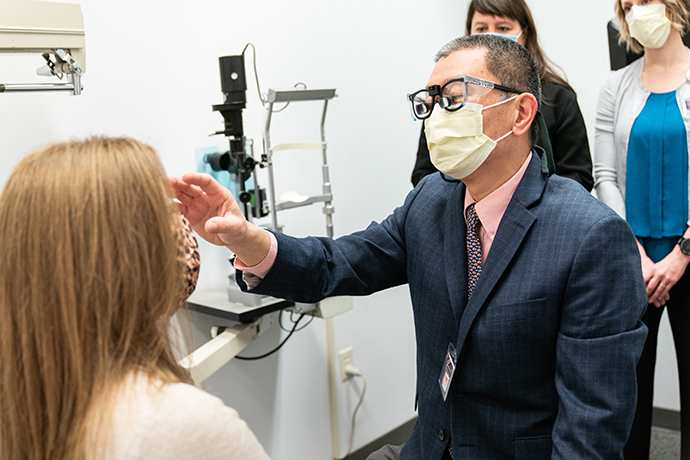 Dr. John Ng examines a patient