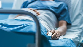 A photo of a patient lying in a hospital bed.
