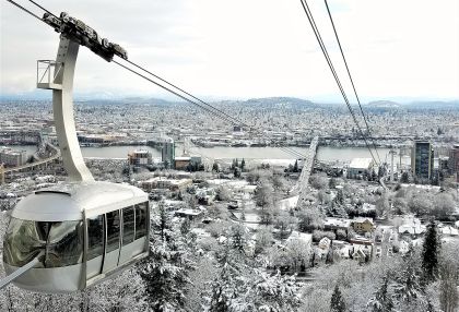 Portland Aerial Tram moving uphill over a snow covered Portland.