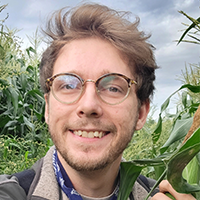Connor Hall takes a portrait photo in a corn field