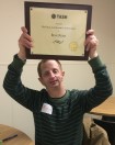 Ross Ryan holds up an award plaque