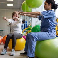 Physical therapist and patient on exercise balls