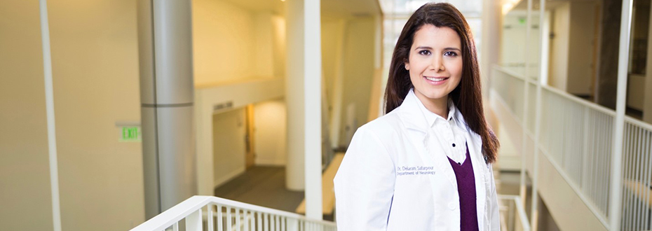 Portrait of Dr. Delaram Safarpour smiling in a white lab coat