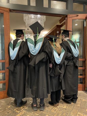 Four DoM Graduates Standing in Their Academic Regalia
