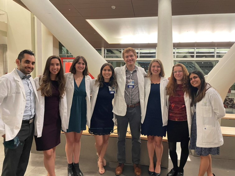 Group of eight students in white coats