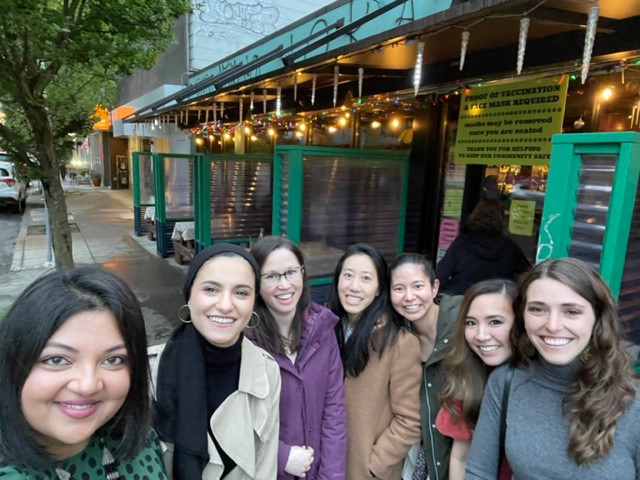 Female ophthalmology residents and assistant program director pose at a restaurant in Portland as part of a wellness acticity.