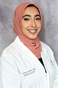 Doctor Yomna Amer smiles in her white coat