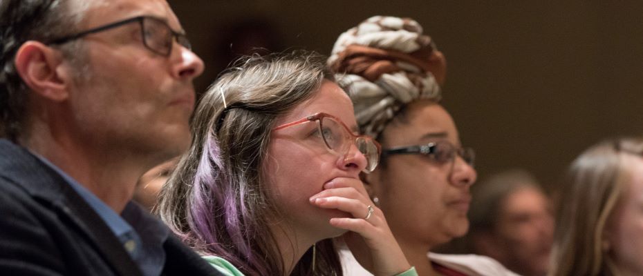 three people listen to a lecture