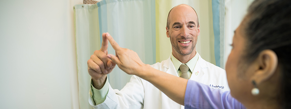 Dr. Matthew Brodsky touching fingers with a Parkinson's patient