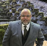 Leo Barriga in a grey suit jacket and tie 