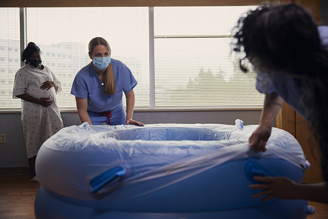 Nurse-midwife Bridget Lee sets up a birthing tub in a patient’s labor and delivery suite.