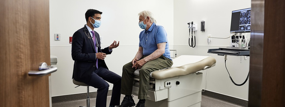 A doctor and a patient are sitting in an examination room together. The doctor is reassuring the patient about their treatment.