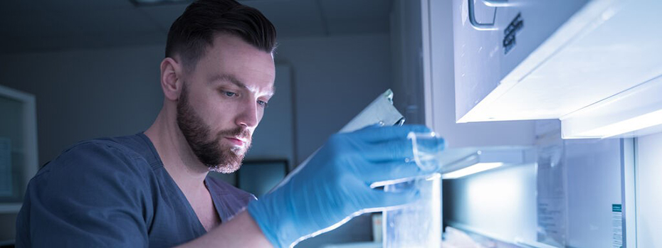 A nuclear medicine technician holds a tube in a laboratory.