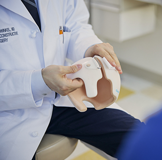 Dr. Erik Wolfswinkel holds an infant-sized cranial orthotic, or helmet.