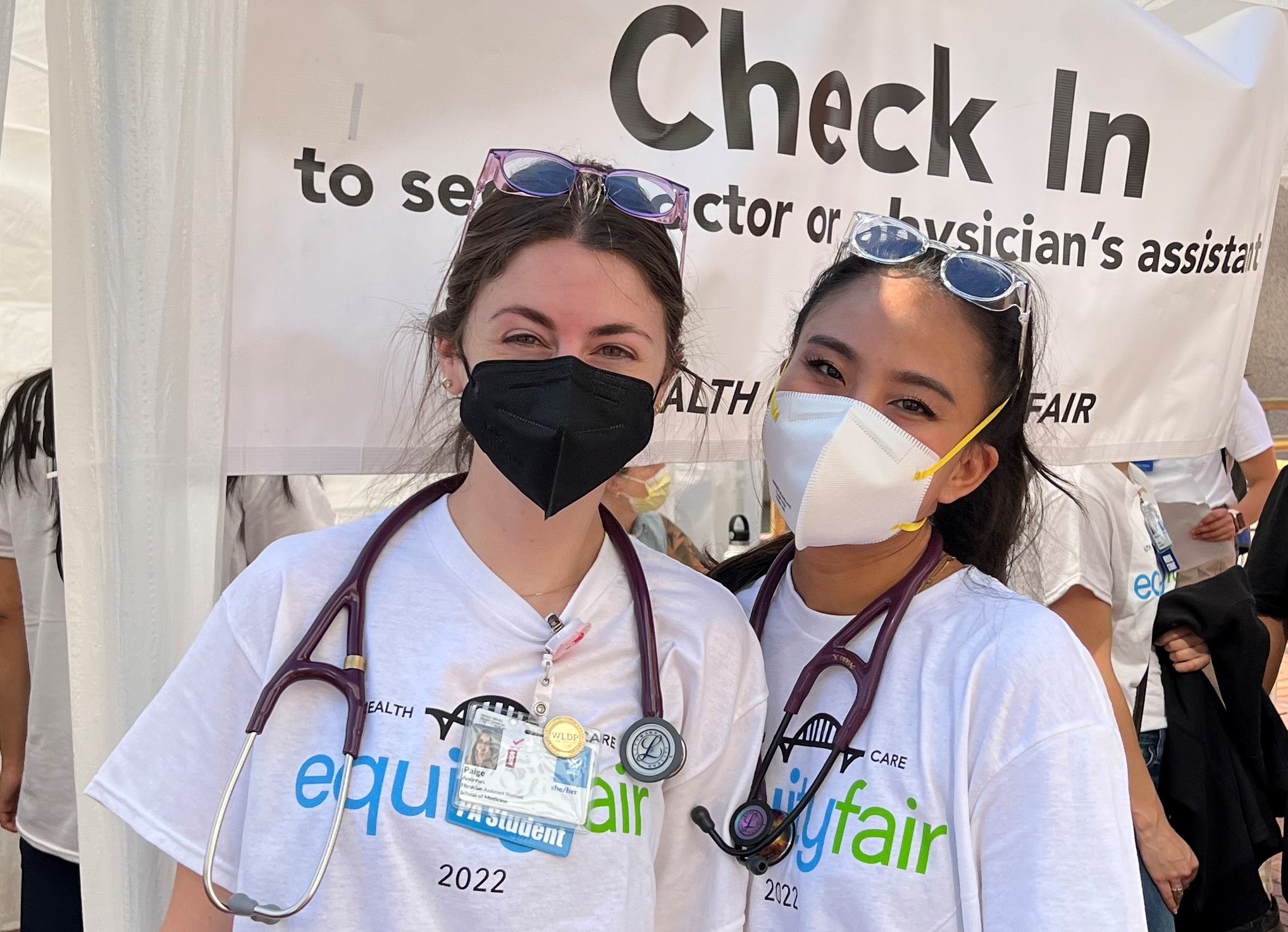 Two physician assistant students standing in front of a tent.