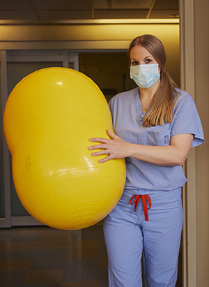 Nurse-midwife Bridget Lee brings a peanut-shaped birthing ball into a patient’s labor and delivery suite.