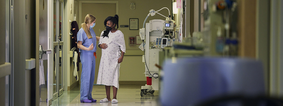 Nurse-midwife Bridget Lee and her patient in labor walk through the hallway of OHSU’s Family Birthing Center.