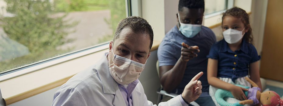 Dr. Winer, pediatric neurosurgeon, shows images to a patient and her parent.