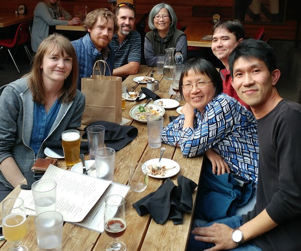 Members of Shyng lab gathered around a table at a restaurant, smiling at the camera.