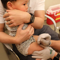 baby receiving a vaccination in the leg