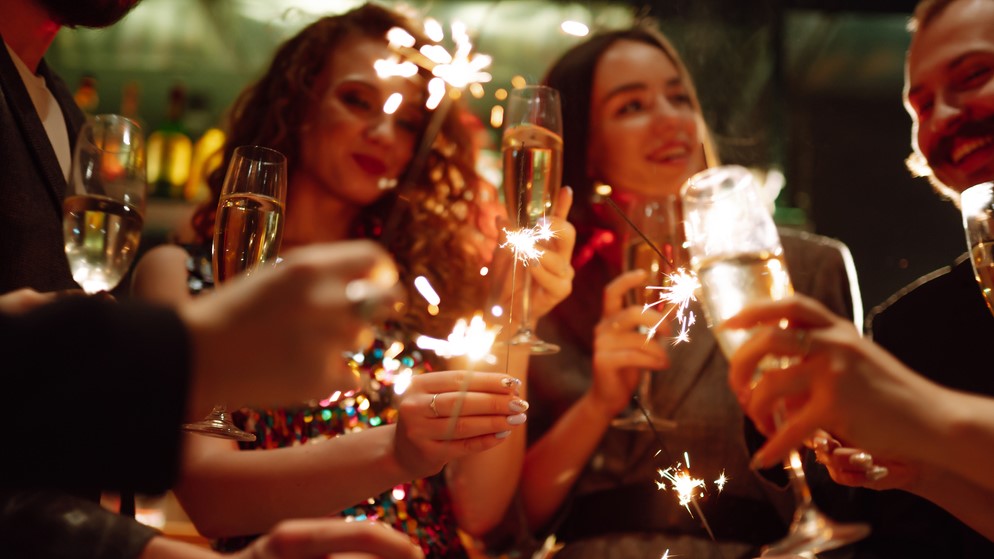 A group of people celebrate with sparklers and champagne