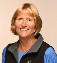 smiling woman wearing a blue shirt and black vest