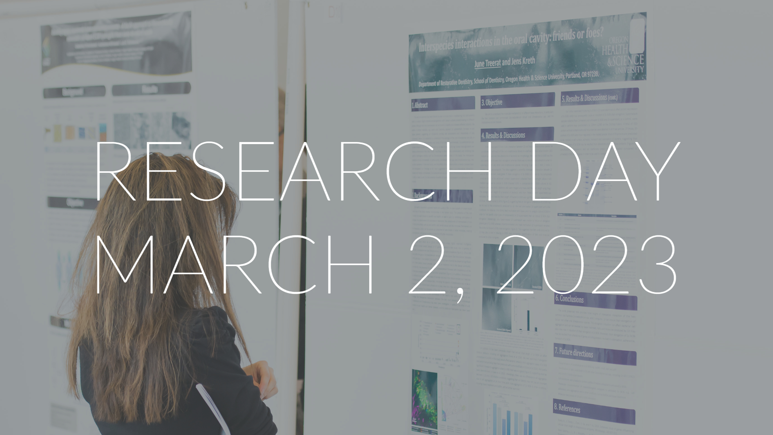 a person looking at a large poster for research day