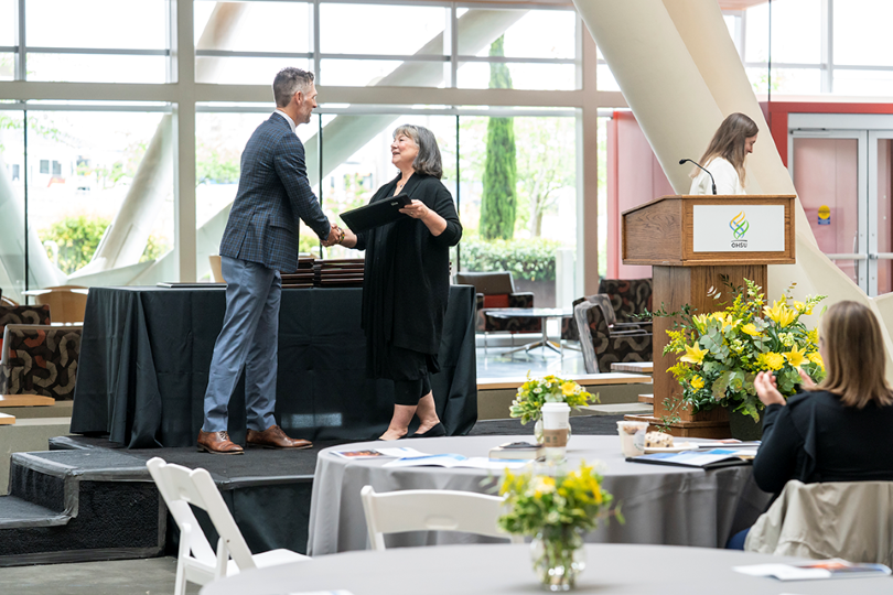 Photo caption: Allison Fryer, Ph.D., bestows Owen McCarty, Ph.D., professor and chair, Department of Biomedical Engineering, with the 2022 John A. Resko Faculty Excellence in Research and Mentoring Award